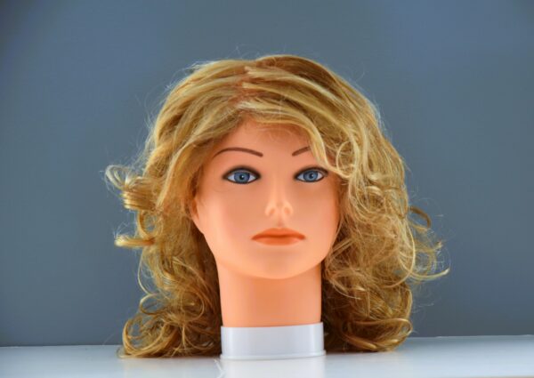 Medium length blond synthetic wig on mannequin head